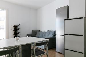 Il comprend une cuisine équipée d'une table blanche et d'un réfrigérateur. dans l'établissement DeHomes - Bicocca Village 28, à Milan