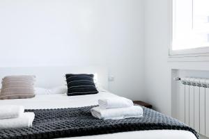1 dormitorio con 1 cama con toallas en DeHomes - Bicocca Village 28, en Milán