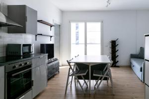 Il comprend une cuisine équipée d'une table, d'une cuisinière et d'un four micro-ondes. dans l'établissement DeHomes - Bicocca Village 28, à Milan