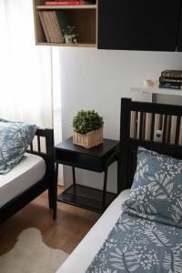 a bedroom with a bed and a table with a plant on it at 2-Bedroom Apt Near City Center in Zagreb