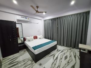 a bedroom with a bed and a television in it at Hotel Vinayak Plaza in Varanasi