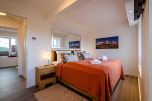 ein Schlafzimmer mit einem Bett mit einer orangefarbenen Tagesdecke in der Unterkunft FeWo Prora - Strandidyll in Binz