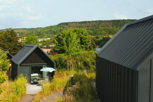 una casa nera con un ombrello in un cortile di TinyLodge 6 a Heilbad Heiligenstadt