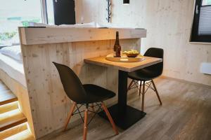 una mesa pequeña con 2 sillas y una botella de vino en TinyLodge 6, en Heilbad Heiligenstadt