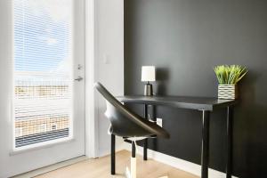 a black desk with a chair next to a window at Modern Home 3BD/3BA Free On-Street Parking & Wi-fi in Baltimore
