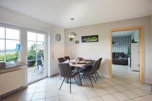 a dining room and living room with a table and chairs at Ferienwohnung Fibbes 4-Sterne in Gebhardshain