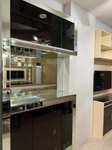 una cocina con armarios negros y electrodomésticos de acero inoxidable en Sea Residences MOA Manila - Jo Alano, en Manila