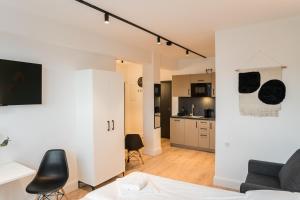 a living room with a couch and a kitchen at Homaris Apartments Hamburg Altona in Hamburg +57 photos