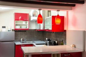 uma cozinha com armários vermelhos e um lavatório em L'Hypercentre / 1 min RER A - 5 min Métro - Disney em Vincennes