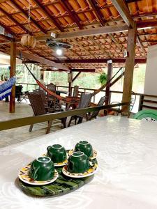 a table with four green plates on top at Sítio com lazer completo em meio a natureza in Marechal Floriano