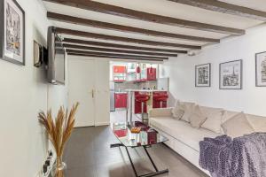 uma sala de estar com um sofá branco e detalhes em vermelho em L'Hypercentre / 1 min RER A - 5 min Métro - Disney em Vincennes