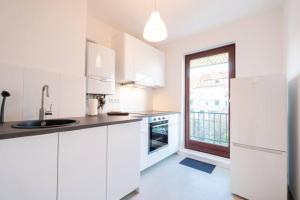 uma cozinha com armários brancos e uma grande janela em Exklusive 2-Zimmer Wohnung für 6 em Bremen
