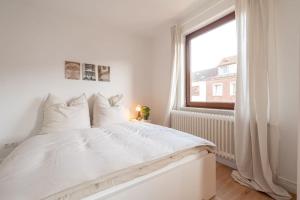 uma cama branca num quarto com uma janela em Exklusive 2-Zimmer Wohnung für 6 em Bremen