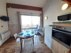 a kitchen and dining room with a table and a microwave at Appartement T2 pour 6 avec balcon et équipements complets, proche navette à Piau-Engaly - FR-1-457-314 in Aragnouet