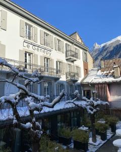 a building with a snow covered tree in front of it at Le Génépy - Appart'hôtel de Charme in Chamonix