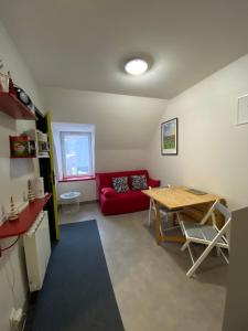 Una sala de estar con un sofá rojo y una mesa. en Les oiseaux T2, en Le Mont-Dore