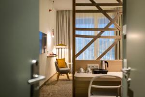 a room with a desk and a chair and a window at ARCOTEL AQ Wien in Vienna