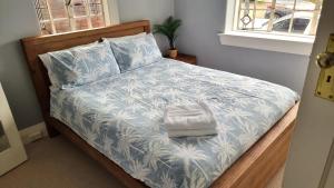 a bed with a blue and white blanket and pillows at Alluring and well-located 2 bed Randwick apartment in Sydney