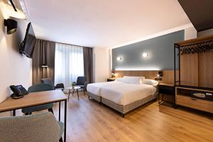 a hotel room with a bed and a desk at Apartamentos Colón 27 in Palencia