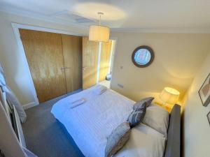 a bedroom with a large bed with a clock on the wall at One Bedroom Flat - Free Parking in Silverstone