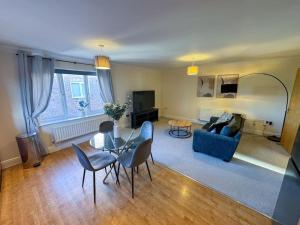 a living room with a blue couch and a table at One Bedroom Flat - Free Parking in Silverstone