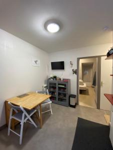Una sala de estar con una mesa y un televisor. en Les oiseaux T2, en Le Mont-Dore