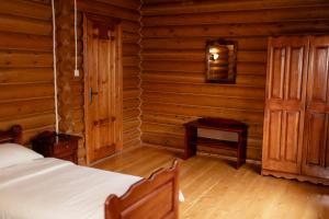 1 dormitorio con 1 cama en una cabaña de madera en Pysana hata, en Volosyanka