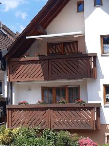 una casa con un balcón de madera con flores. en Ferienwohnung Lechleiter, en Kappelrodeck