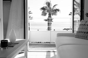 a living room with a view of a palm tree at Hotel La Ciotat - A deux pas de l'eau in La Ciotat
