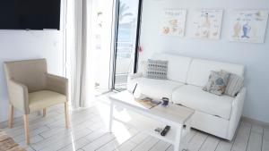 a living room with a white couch and a chair at Hotel La Ciotat - A deux pas de l'eau in La Ciotat