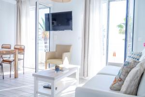 a living room with a white couch and a table at Hotel La Ciotat - A deux pas de l'eau in La Ciotat