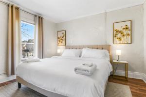 ein Schlafzimmer mit einem großen weißen Bett mit Handtüchern darauf in der Unterkunft Contemporary Urban Home in Niagara Falls