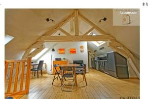 ein Zimmer mit Tisch und Stühlen auf dem Dachboden in der Unterkunft Orléans Appartement 2 chambres avec Parking in Orléans