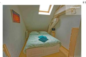 ein kleines Schlafzimmer mit einem Bett im Dachgeschoss in der Unterkunft Orléans Appartement 2 chambres avec Parking in Orléans