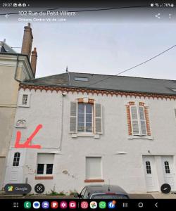 ein weißes Gebäude mit einem k-Schild an der Seite in der Unterkunft Orléans Appartement 2 chambres avec Parking in Orléans