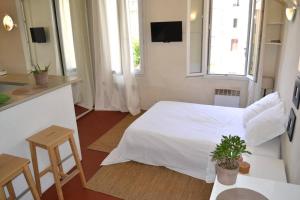 een slaapkamer met een wit bed en 2 ramen bij Studio des Cardeurs au coeur du centre historique in Aix-en-Provence