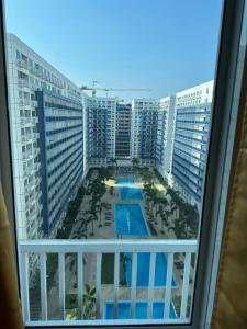vistas a la piscina desde el balcón de un hotel en Sea Residences MOA Manila - Jo Alano, en Manila