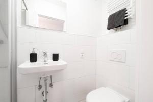 a white bathroom with a sink and a toilet at Sehr schöne Wohnung für 6 Pers. in Bremen