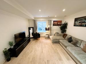 ein Wohnzimmer mit einem Sofa und einem Flachbild-TV in der Unterkunft Newcastle Quayside - Sleeps 8 - Central Location - Parking Space Included in Newcastle upon Tyne