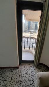 a door to a room with a view of a balcony at ADMF*KR5 in Abu Dhabi