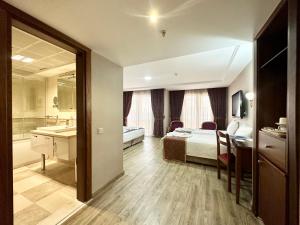 イスタンブールにあるAskoc Hotel & SPAのベッドとバスルーム付きのホテルルームです。