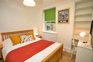 a bedroom with a bed and a window and shelves at Finest Retreats - Hill Rise in Richmond