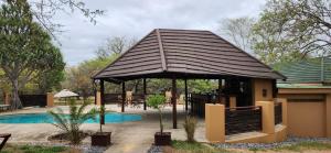 a gazebo with a table and a pool at Motlala Game Lodge in Hoedspruit