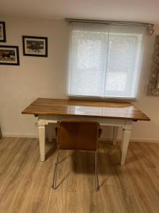 een houten tafel met een stoel en een raam bij BB Home in Altenstadt