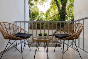 two chairs and a table on a balcony at Charming two bedrooms Apartment walk to Acropolis in Athens