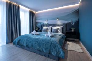 a blue bedroom with a bed with pillows at Willa Szycha in Karpacz