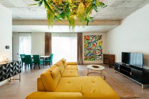 a living room with a yellow couch and a television at Centro Accommodation in Cluj-Napoca