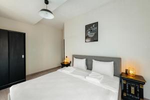 a bedroom with a large bed with white sheets at Centro Accommodation in Cluj-Napoca