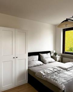 ein weißes Schlafzimmer mit einem Bett und einem Fenster in der Unterkunft Wunderschöne 3-Zimmer Wohnung für 8 Personen in Bremen