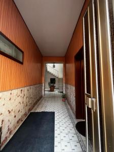 pasillo con paredes de color naranja y suelo de baldosa. en Il Vigneto, en Trapani